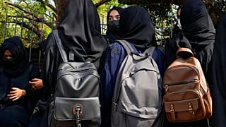 Estudantes à espera em frente da escola com lenço na cabeça