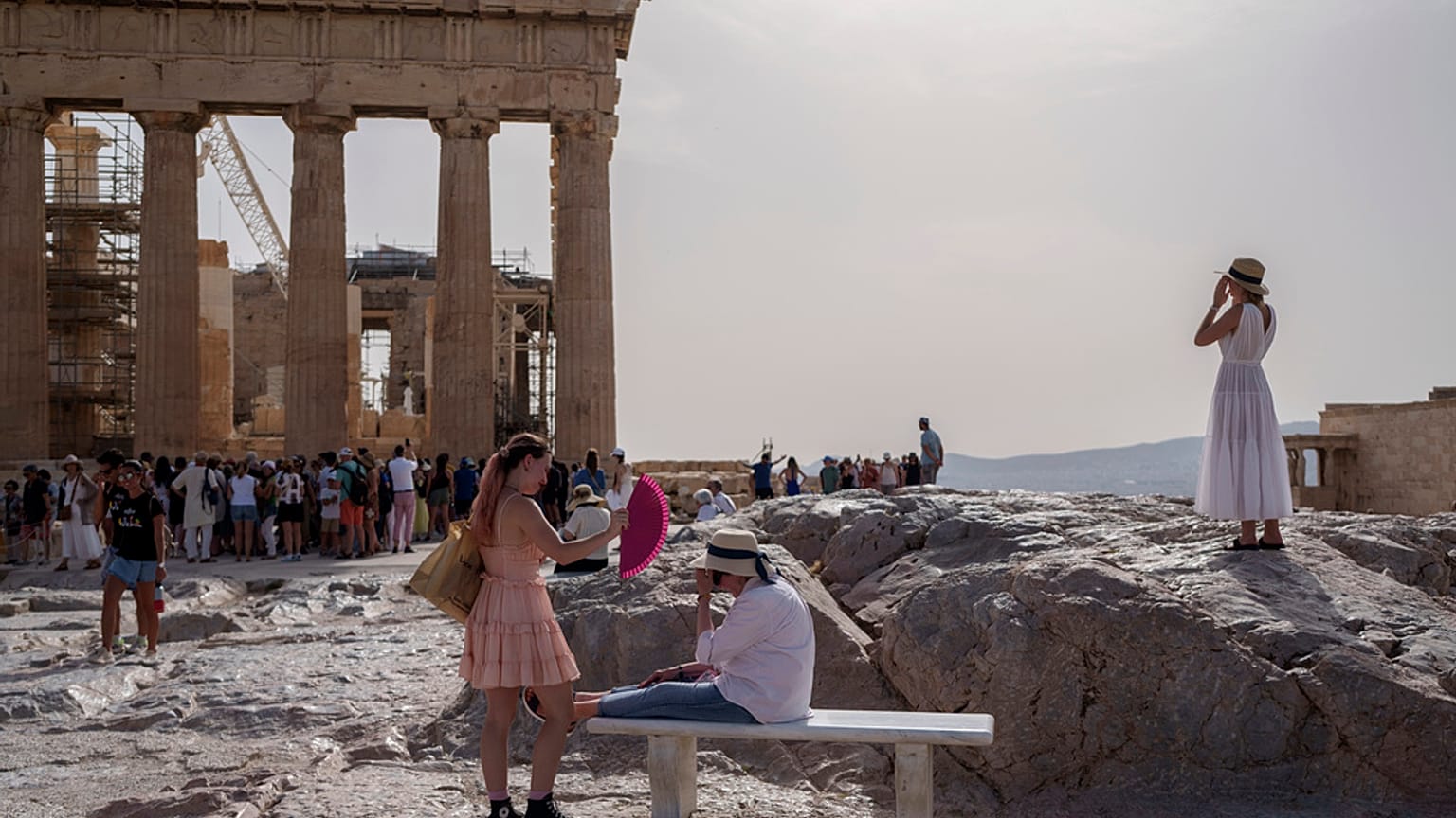 Imagen de varias personas en el espacio turístico de la Acrópolis en Atenas.