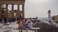 Imagen de varias personas en el espacio turístico de la Acrópolis en Atenas.