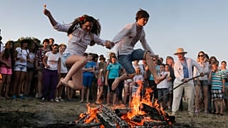 Los saltos de una hoguera son populares celebraciones en muchos lugares de este día