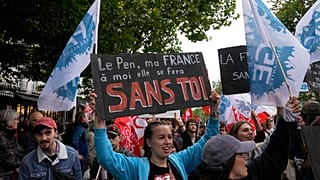 Una manifestante tiene un cartello contro l'estrema destra con la scritta "Le Pen, la mia Francia avverrà senza di te" durante una manifestazione a Parigi, il 15 giugno 2024