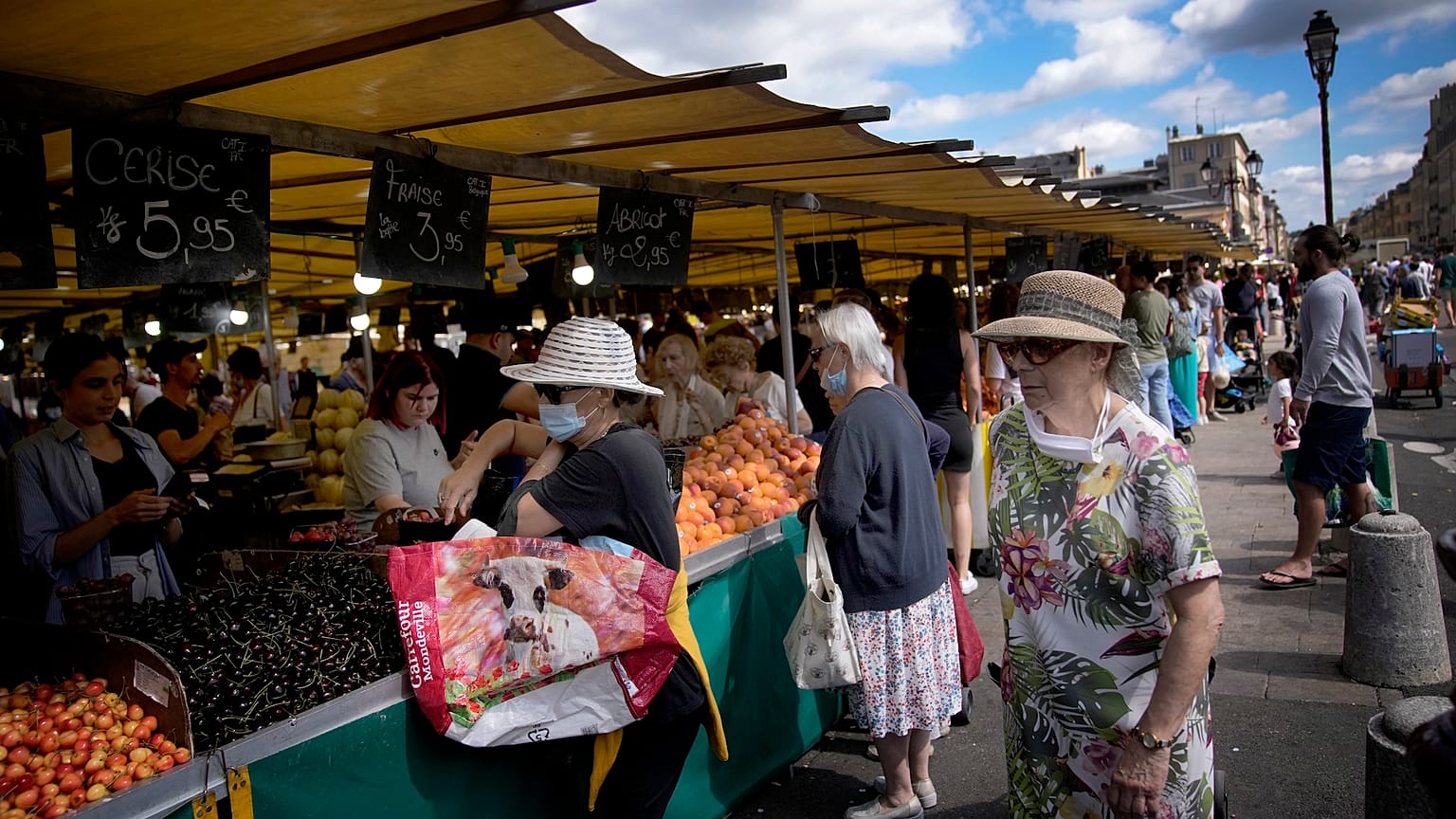 People shop at a market in Versailles, outside Paris, France