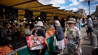 People shop at a market in Versailles, outside Paris, France