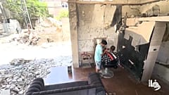 Umgeben von Trümmern schneidet der 26-Jährige Abdullah Tawfiq Ramada einem Kunden die Haare. 