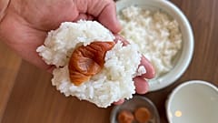 Onigiri sind gefüllte Reiskugeln aus Japan, hier mit gesalzener Pflaume, oder "umeboshi".