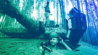 A Ukrainian soldier from 57th brigade looks out from a Swedish Combat Vehicle 90 near front line in Kharkiv region, 18 June 2024