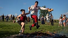 A couple jumps over the fire at a traditional Midsummer Night celebration near capital Kyiv, Ukraine.