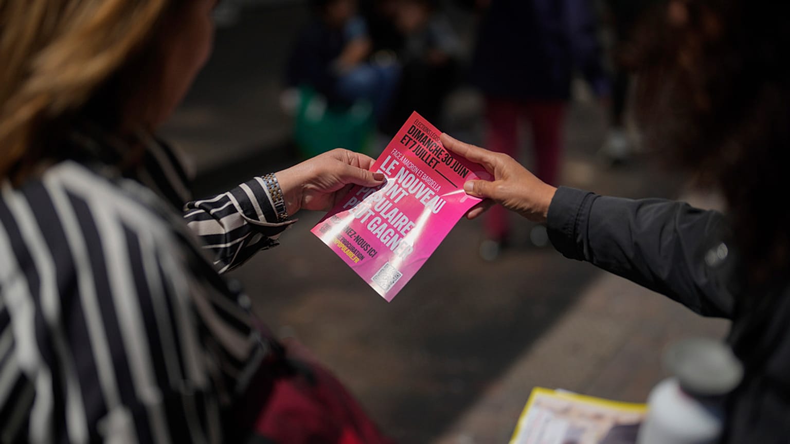 Voluntário da campanha dos candidatos da Nova Frente Popular distribui folhetos eleitorais para as próximas eleições legislativas em Paris, sábado, 22 de junho de 2024.
