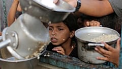 صبي فلسطيني يشاهد حصته من المساعدات الغذائية قبل عطلة عيد الأضحى المقبلة في خان يونس