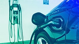 A hybrid car is seen charging at a charging station at a parking garage in Los Angeles, October 2018