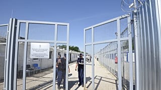 2017-es fotó: rendőrök hajtják be a röszkei tranzitzóna kapuját