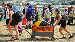 Festival goers arrive at the Glastonbury Festival in Worthy Farm, Somerset, England, Wednesday, June 26, 2024.