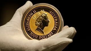 Um funcionário da casa de ouro ProAurum apresenta a moeda de ouro australiana de 1 kg - pureza 999,9 na sala de cofres em Munique, Alemanha, quinta-feira, 13 de dezembro de 2018. (AP Photo/