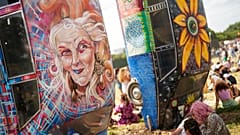 Festivaleiros sentam-se perto de Carhenge durante o Festival de Glastonbury em Worthy Farm, Somerset, Inglaterra, quinta-feira, 27 de junho de 2024.