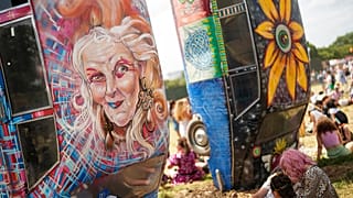 Festivaleiros sentam-se perto de Carhenge durante o Festival de Glastonbury em Worthy Farm, Somerset, Inglaterra, quinta-feira, 27 de junho de 2024.