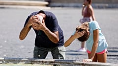 Touristen erfrischen sich an einem Brunnen auf der Piazza del Popolo in Rom, während das afrikanische Hochdruckgebiet die Temperaturen in ganz Italien wieder ansteigen lässt u