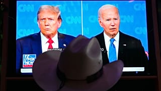 A man wears a cowboy hat as he watches the presidential debate between Joe Biden and Donald Trump in Scottsdale, AZ, 27 June 2024