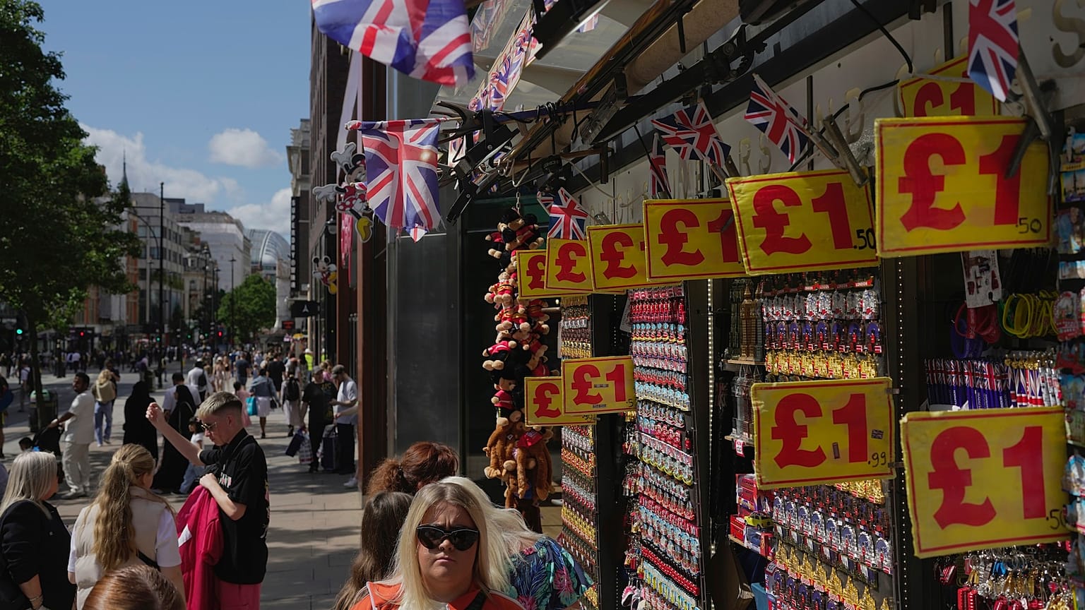 People walk along a street in a shopping district in central London