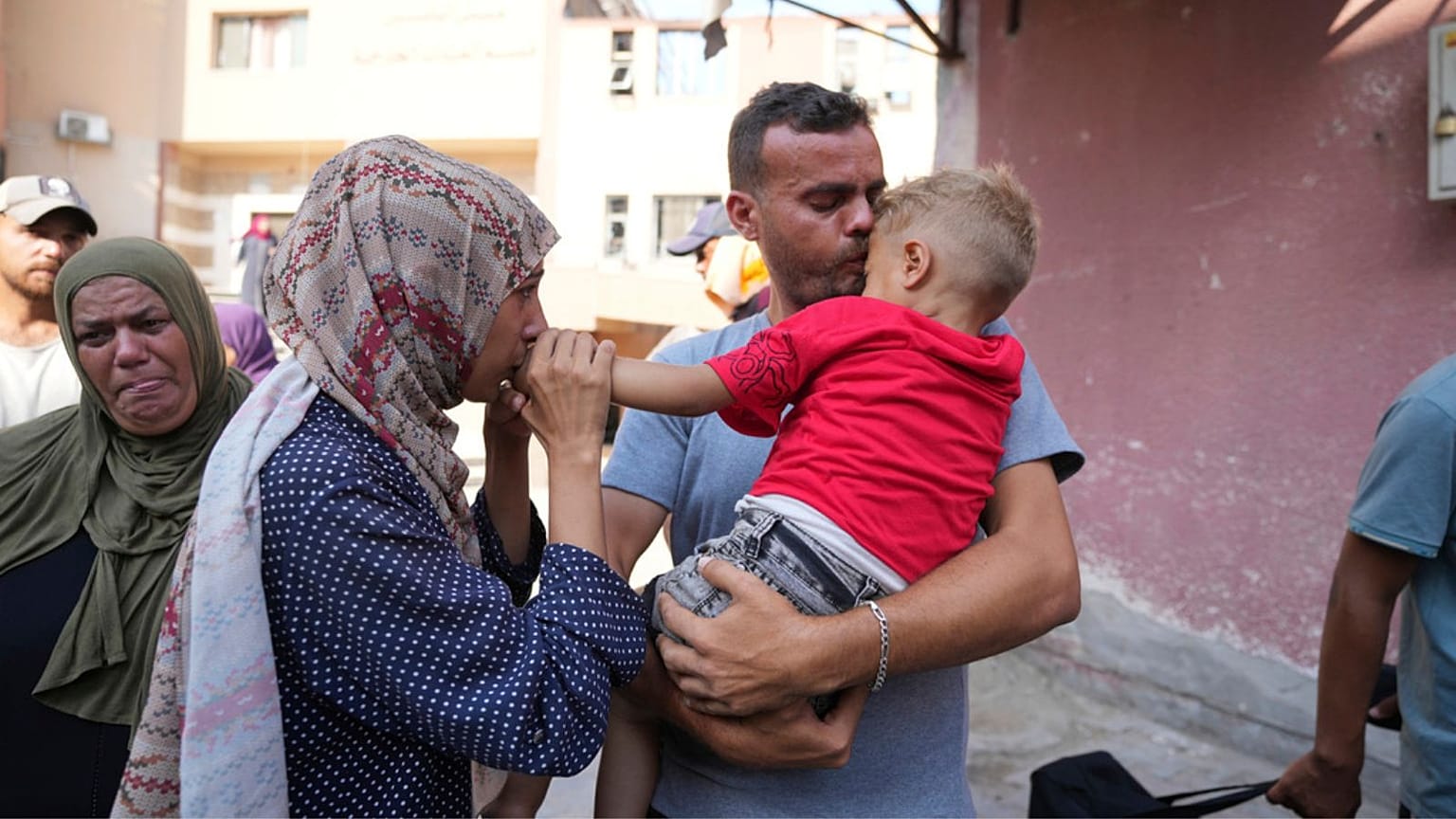 Palestinian parents say goodbye to their sick son before leaving the Gaza Strip to get treatment abroad through the Kerem Shalom crossing