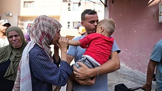 Palestinian parents say goodbye to their sick son before leaving the Gaza Strip to get treatment abroad through the Kerem Shalom crossing