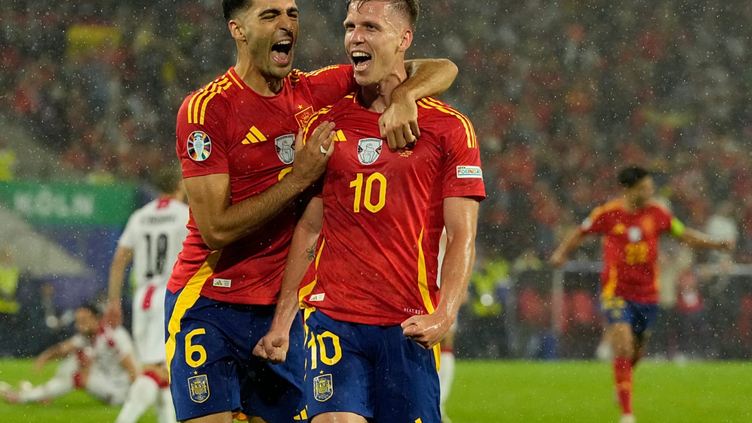 L'Espagnol Dani Olmo, à droite, célèbre le 4e but de son équipe contre la Géorgie lors d'un huitième de finale de l'Euro 2024 à Cologne.