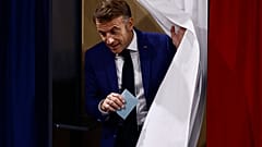Le président français Emmanuel Macron quitte l'isoloir avant de voter au Touquet-Paris-Plage, dans le nord de la France, dimanche 30 juin 2024.