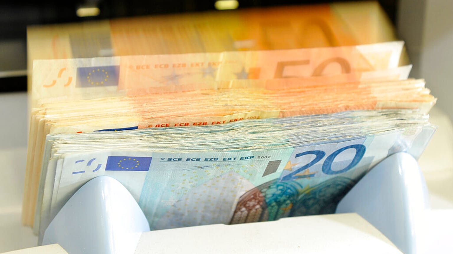 Un hombre pasa junto a un cartel del euro en el vestíbulo del Banco Central Europeo en Fráncfort, Alemania,