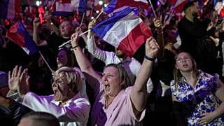 I sostenitori della leader dell'estrema destra francese Marine Le Pen reagiscono dopo la pubblicazione delle proiezioni basate sull'effettivo conteggio dei voti.