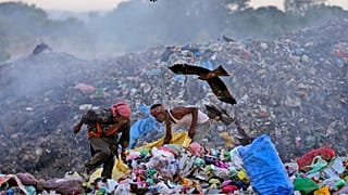 Waste pickers Salmaa and Usmaan Shekh, right, search for recyclable materials during a heat wave at a garbage dump on the outskirts of Jammu, India