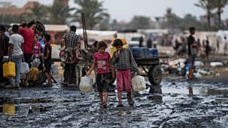 Los palestinos se reúnen para llenar garrafas de agua en Deir al-Balah, Franja de Gaza, el 20 de junio de 2024.