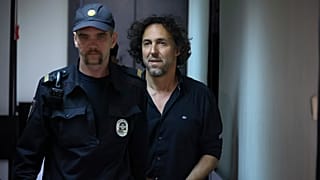 French citizen Laurent Vinatier, right, is escorted into a cage in a courtroom in the Zamoskvoretsky District Court in Moscow.