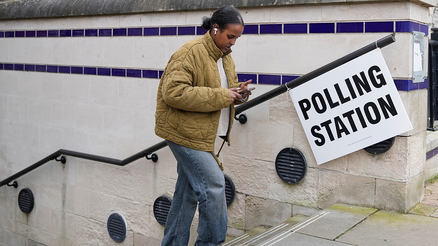 Une femme quitte un bureau de vote après avoir voté à Londres.
