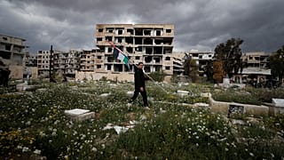 شاب يحمل علم فلسطين في مخيم اليرموك بالعاصمة السورية دمشق