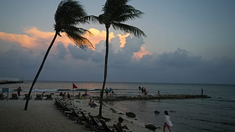 People lounge on the beach as the sun sets ahead of Hurricane Beryl's expected arrival, in Playa del Carmen, Mexico, Wednesday, July 3, 2024.
