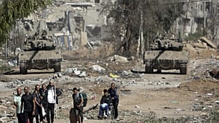 Palestinians flee to northern Gaza as Israeli tanks block the Salah al-Din road in the central Gaza Strip on Nov. 24, 2023