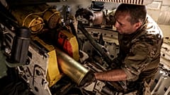 Ein Soldat bereitet den Abschuss einer sowjetischen 120-mm-Haubitze vom Typ "Gvozdika" auf russische Stellungen am Stadtrand von Chasiv Yar vor, 22. Juni 2024