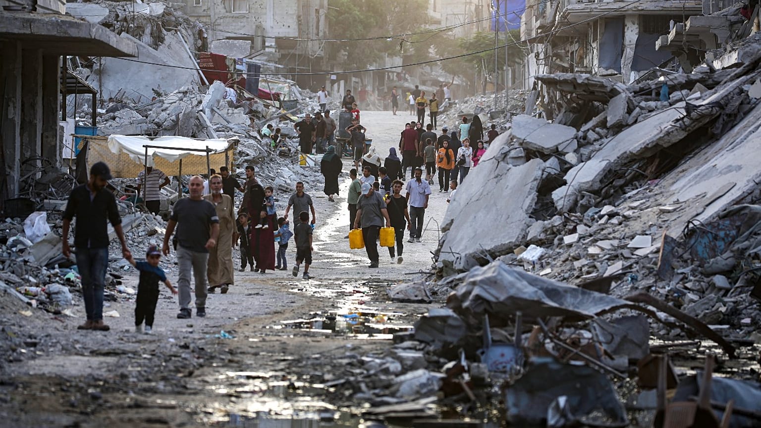 نازحون فلسطينيون بسبب الهجوم الإسرائيلي على غزة يسيرون عبر مياه الصرف الصحي في شوارع خان يونس الجنوبية، الخميس 4 يوليو 2024.