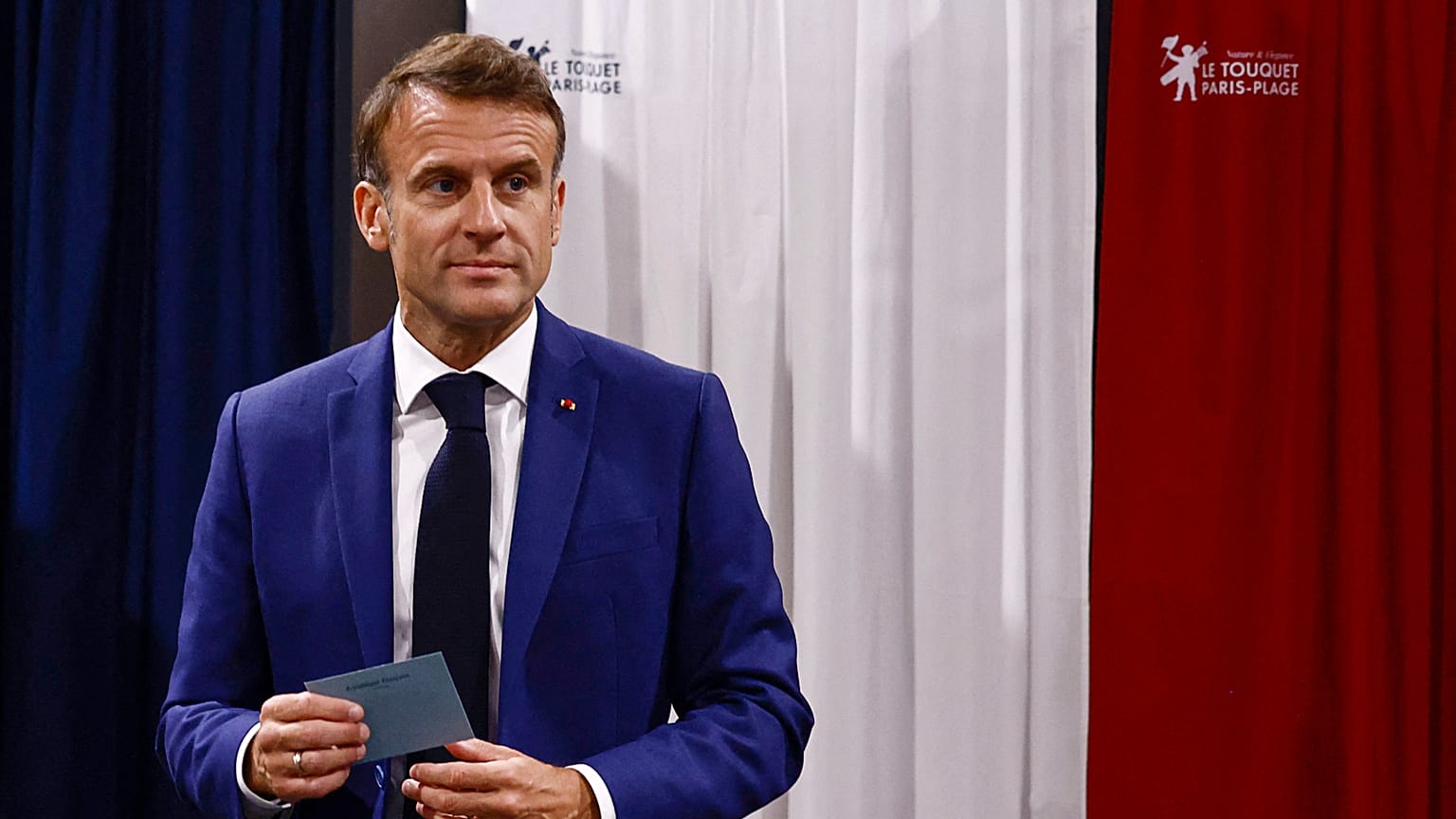 ARQUIVO - O Presidente francês Emmanuel Macron sai da cabina de voto antes de votar nas eleições legislativas antecipadas em França.