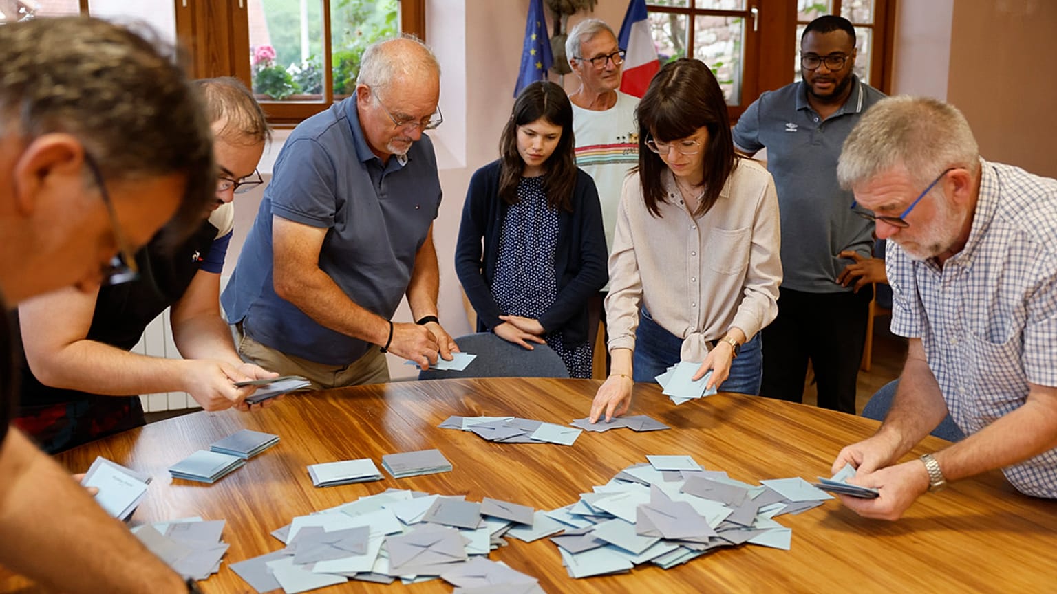 Assistenti elettorali contano le schede in una postazione di voto a Soultz-Les-Bains, Francia orientale, domenica 30 giugno 2024