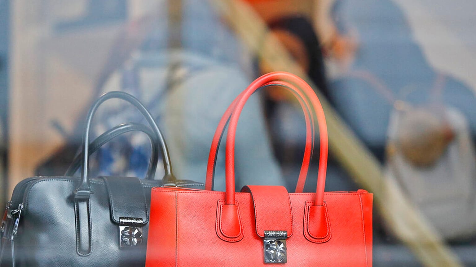 Women shop for bags in a luxurious outlet mall in London, Friday, Oct. 21, 2016. 