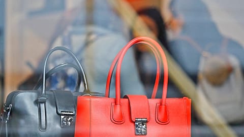 Women shop for bags in a luxurious outlet mall in London, Friday, Oct. 21, 2016. 