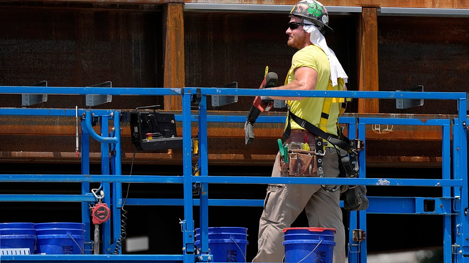 A worker uses a towel for protection from the sun