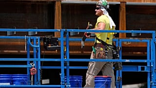 A worker uses a towel for protection from the sun