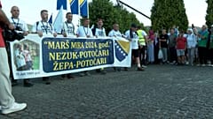Menschen halten einen Banner bei dem Friedensmarsch in Srebrenica.