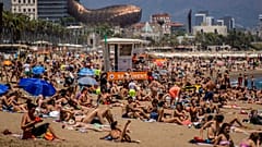 Des personnes prennent un bain de soleil sur la plage de Barcelone, en Espagne, le 9 juillet 2021. 