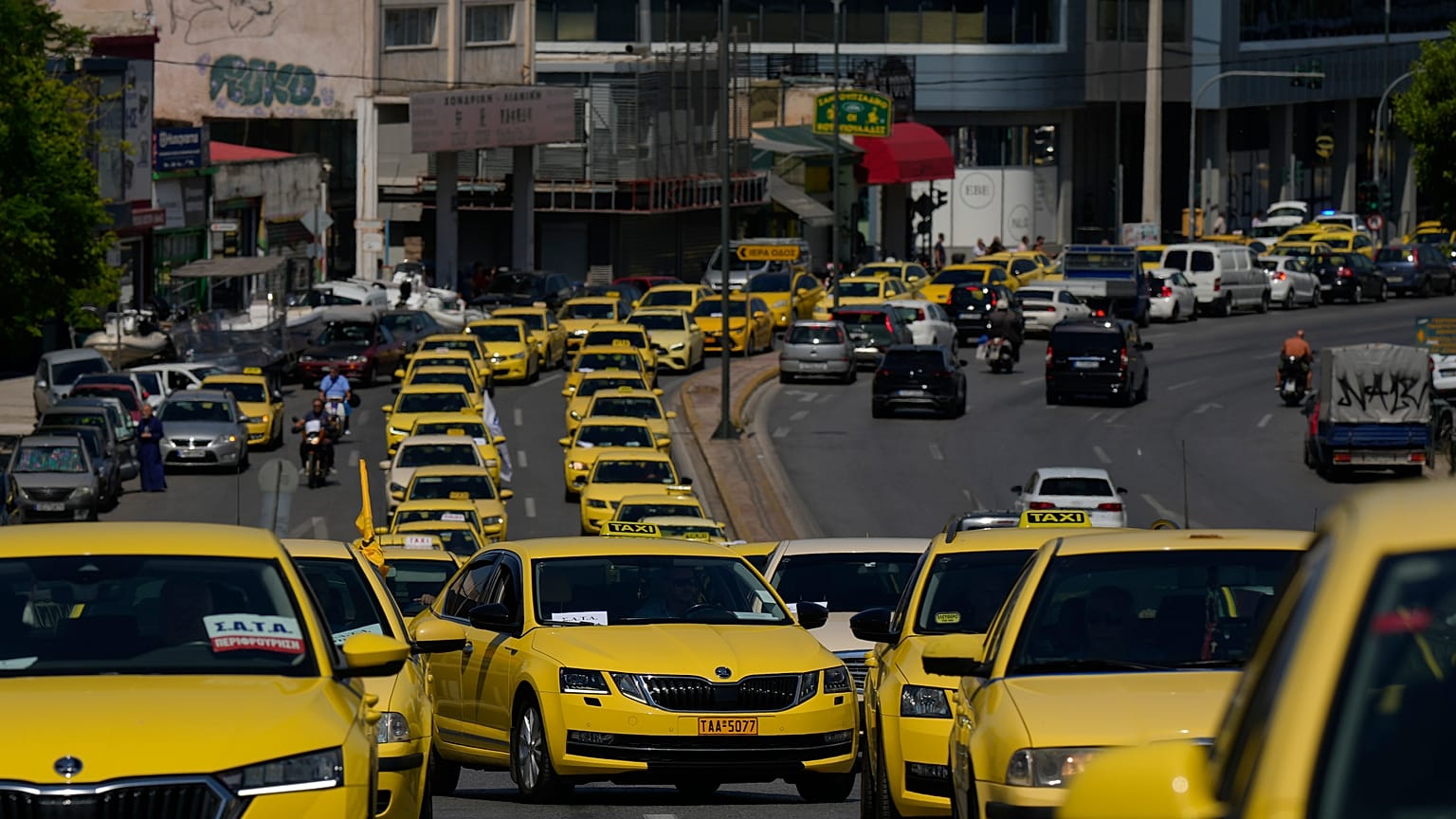 Des chauffeurs de taxi conduisent leurs véhicules alors qu'ils manifestent à Athènes, le jeudi 11 juillet 2024.