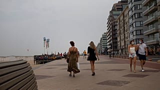 Pessoas caminham no passeio marítimo ao longo da costa na estância balnear belga de Knokke, na Bélgica, terça-feira, 11 de agosto de 2020.