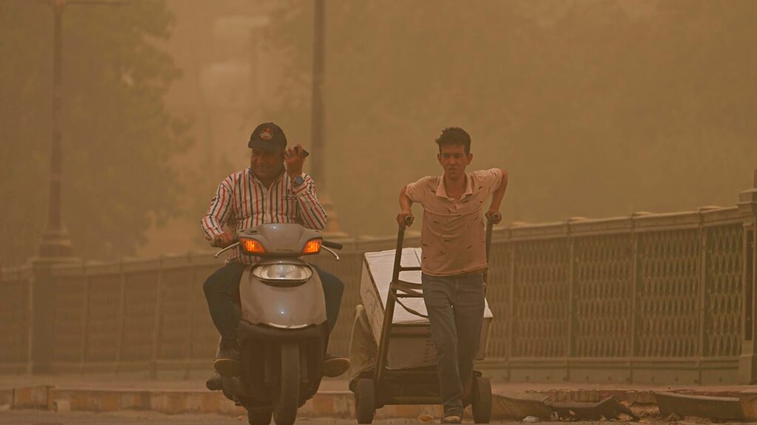 In the eye of the storm: People walk on a bridge during a sandstorm in Baghdad, Iraq in 2022