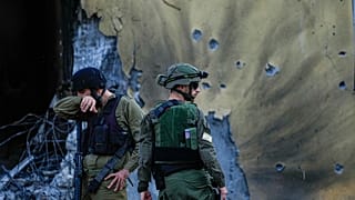 İsrail askerleri, 14 Ekim 2023 Cumartesi günü İsrail'in Kibbutz Be'eri bölgesinde Hamas militanları tarafından yıkılan evlerin önünden geçiyor. 