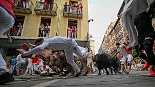 Des fêtards courent avec des taureaux du ranch de Jandilla lors du sixième jour de la course de taureaux des fêtes de San Fermín à Pampelune, le vendredi 12 juillet 2024